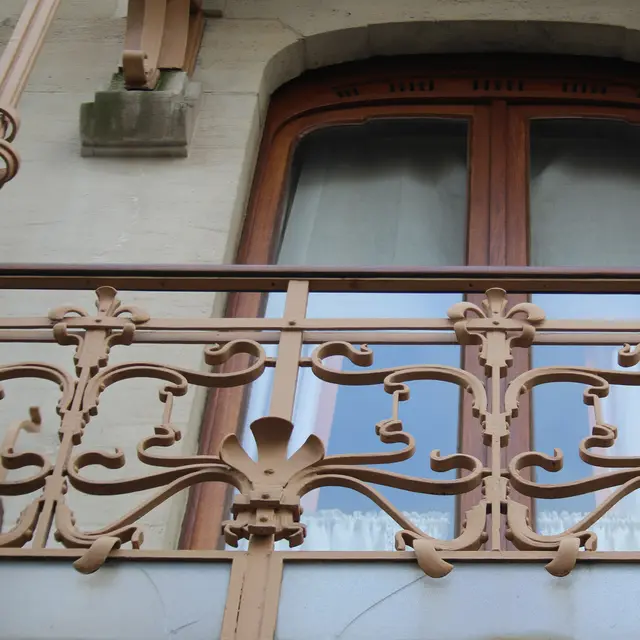 A curling wrought-iron balcony rail on the façade of Horta's house