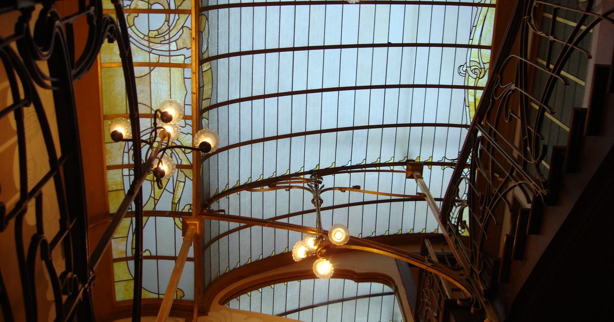 Looking up the stairwell of Victor Horta's house in Saint-Gilles, Brussels, towards the stained-glass skylight, with curving iron banisters